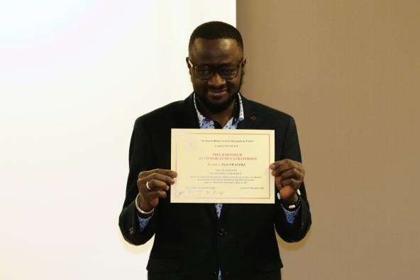 Paul Owagoke présente son diplôme